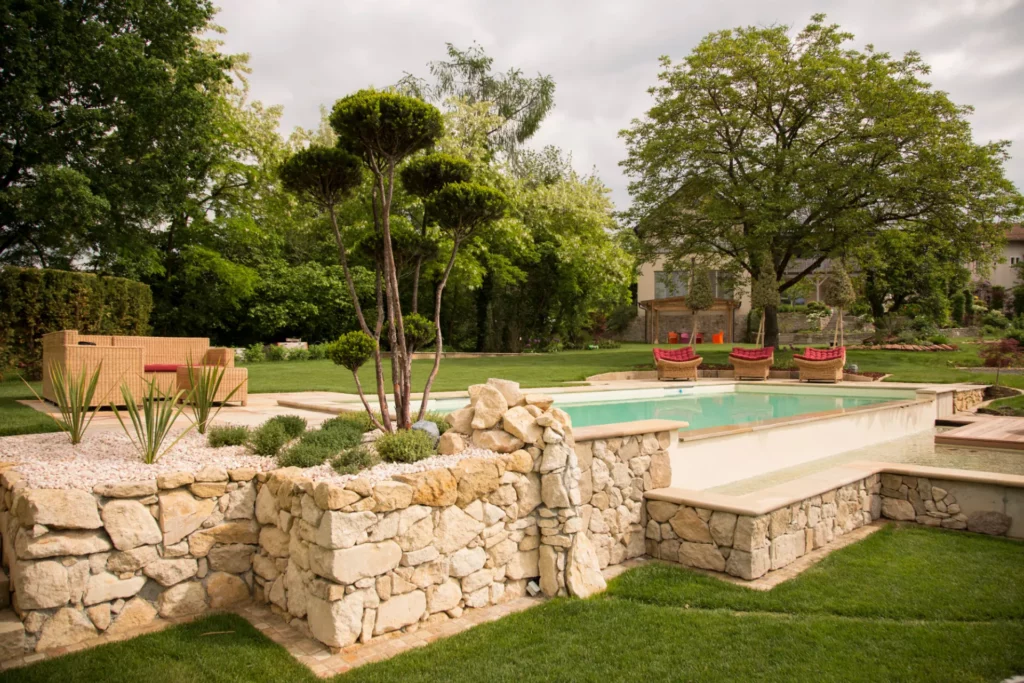 Ein Naturpool mit Steinmauer als Fundament