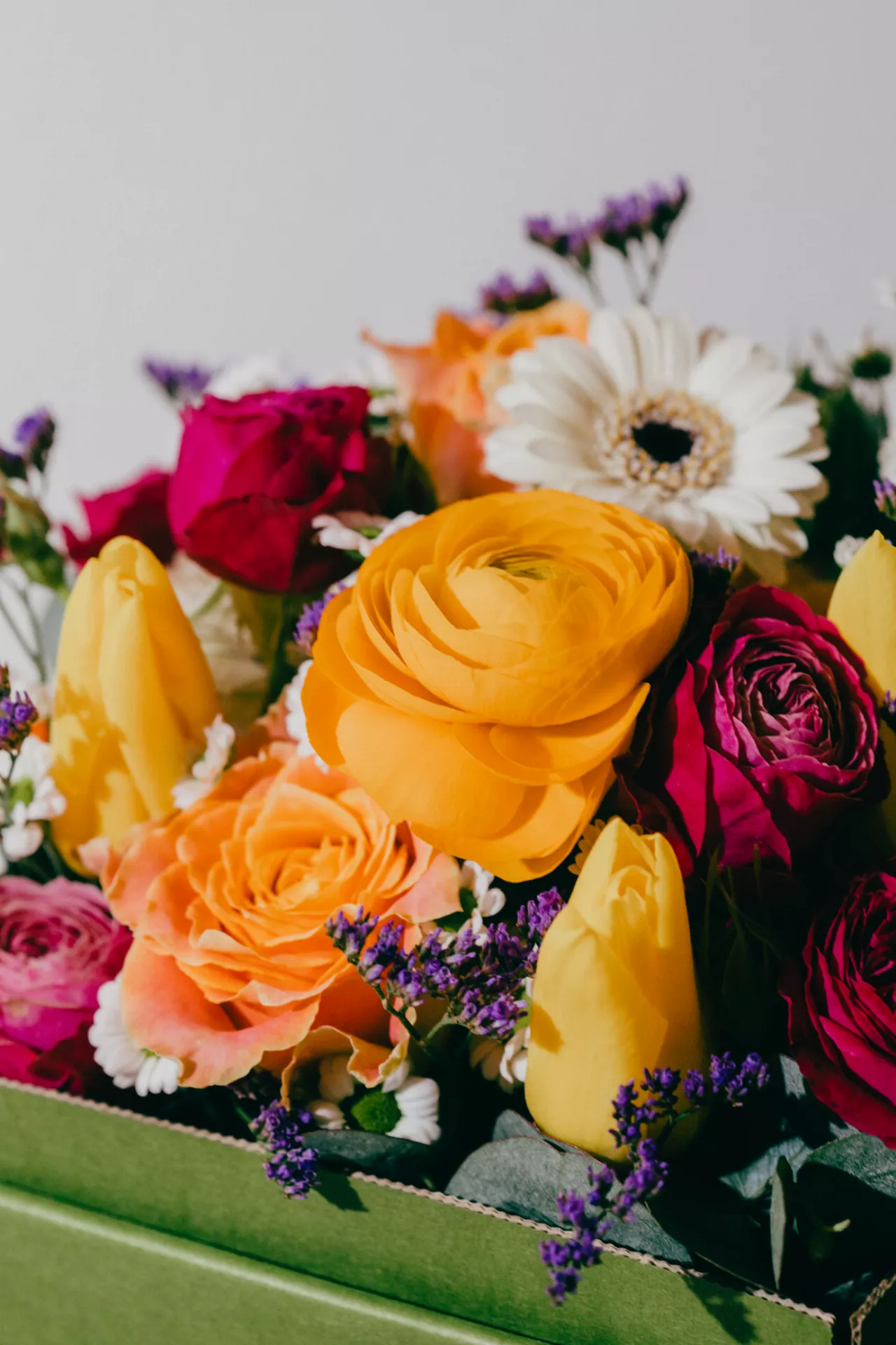 Orange, rote und weitere Blumen in einer grÃ¼nen Blumenbox