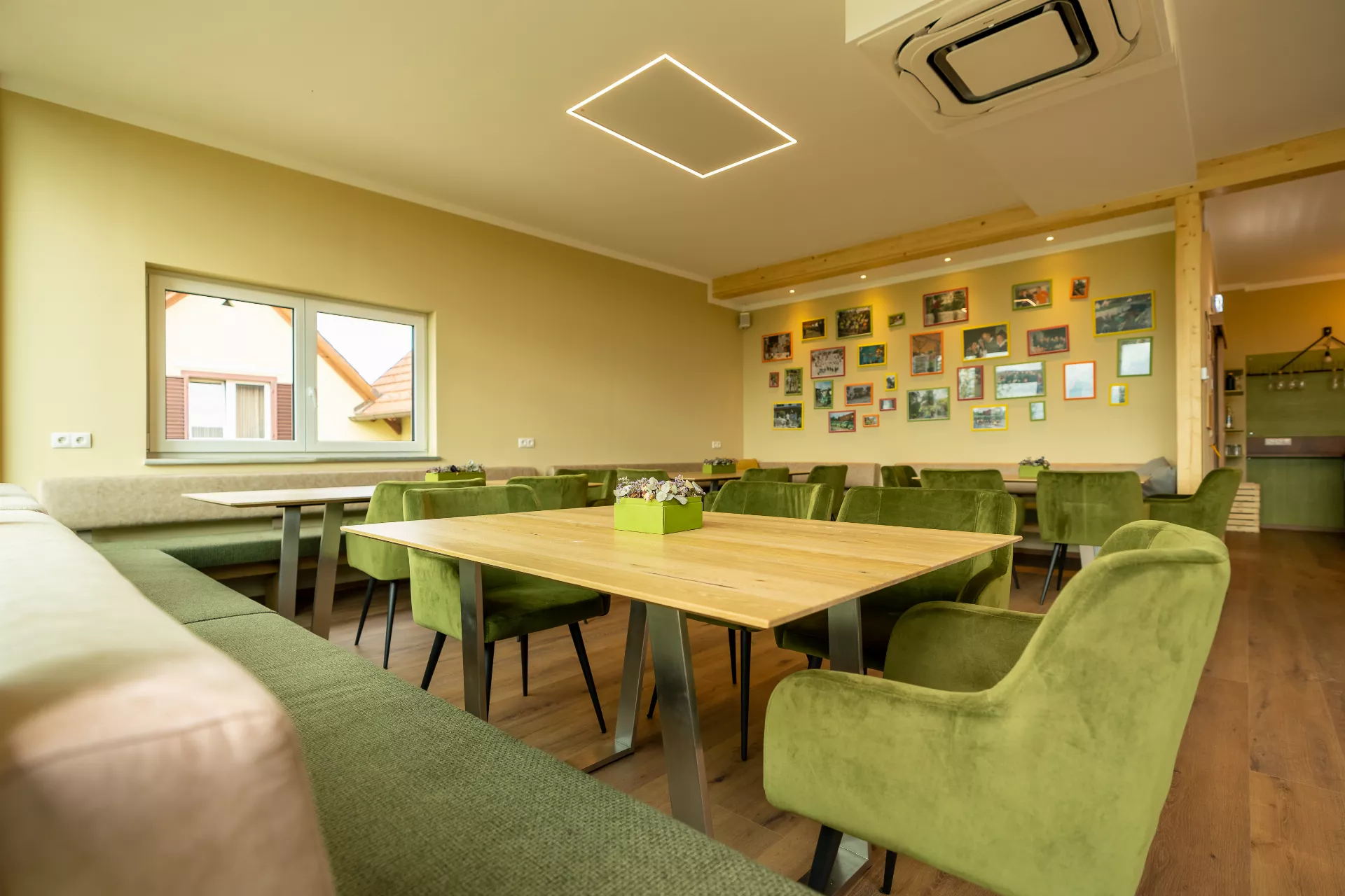 Ein Zimmer mit einem Holztisch und grÃ¼nen StÃ¼hlen