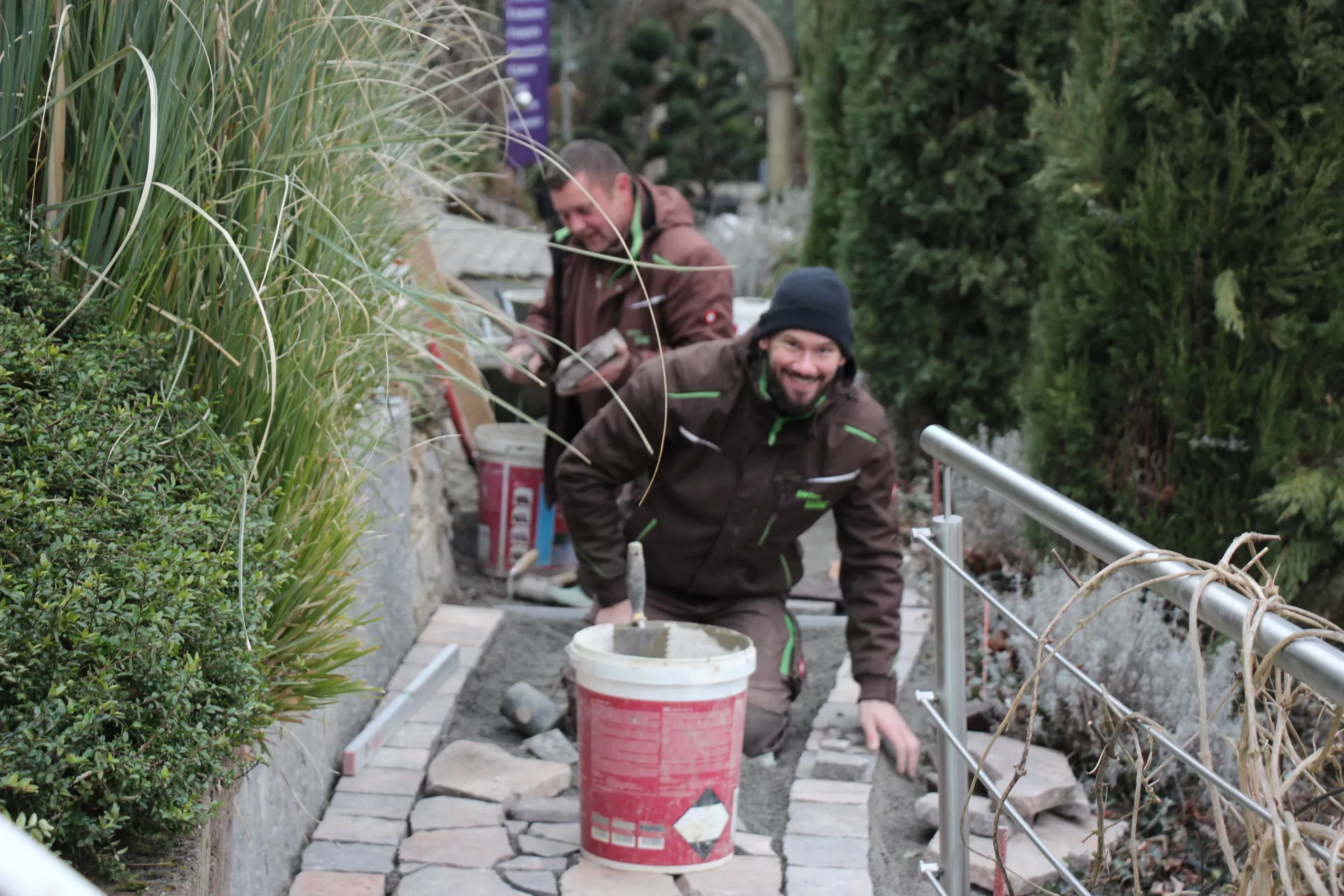 Mitarbeiter aus der Gartengestaltung beim Platten verlegen